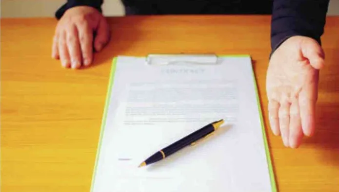 Contrat pos&eacute; sur une table avec un stylo, en attente de signature