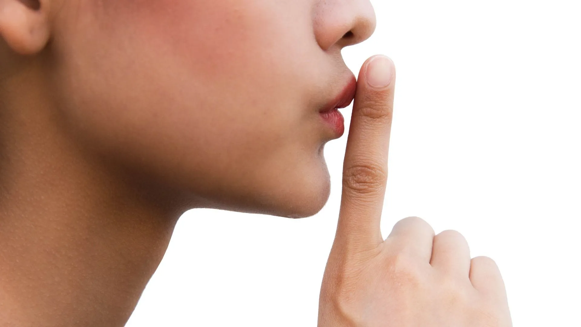 Une personne pose son index verticalement devant ses l&egrave;vres pour r&eacute;clamer le silence.