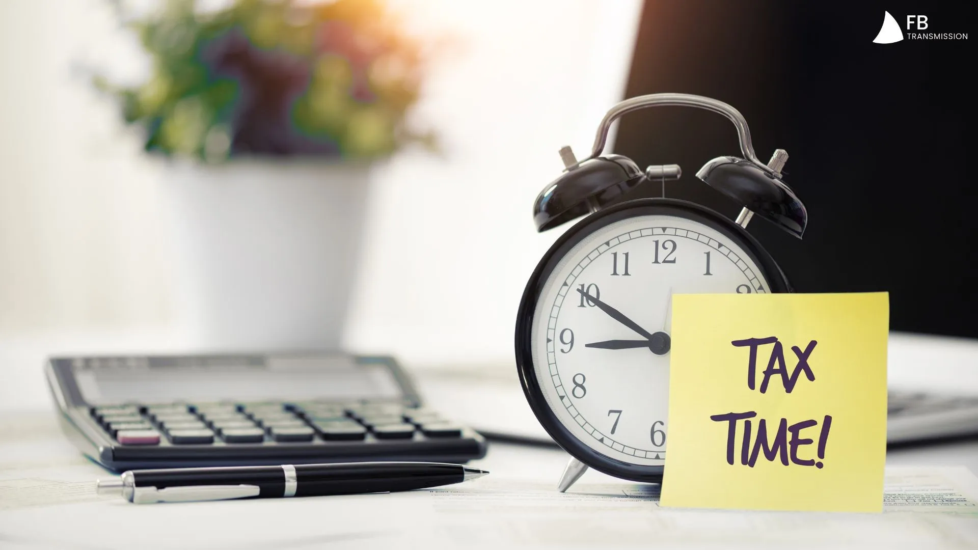 Un r&eacute;veil noir est pos&eacute; &agrave; c&ocirc;t&eacute; d'un post-it jaune indiquant &laquo; TAX TIME! &raquo;