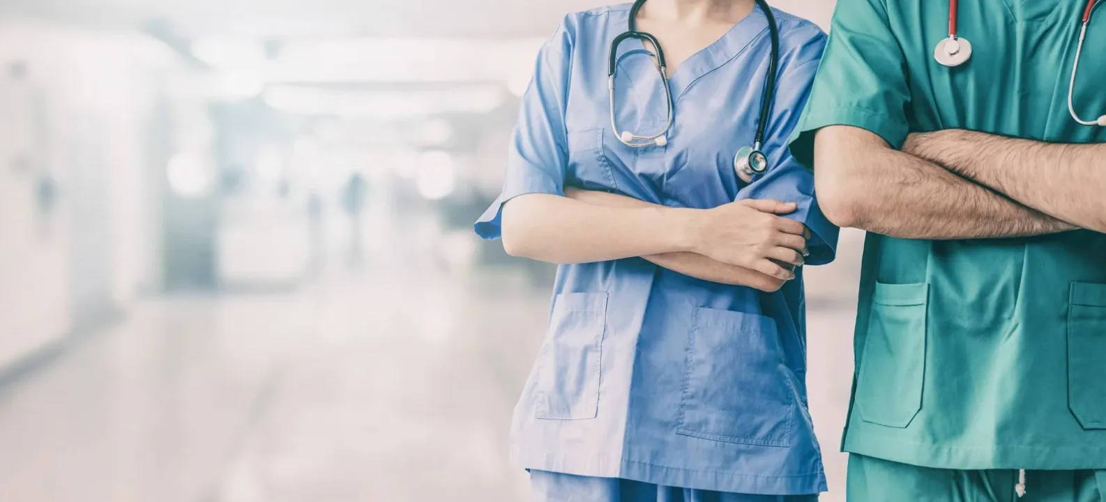 Deux soignants en blouse m&eacute;dicale les bras crois&eacute;s
